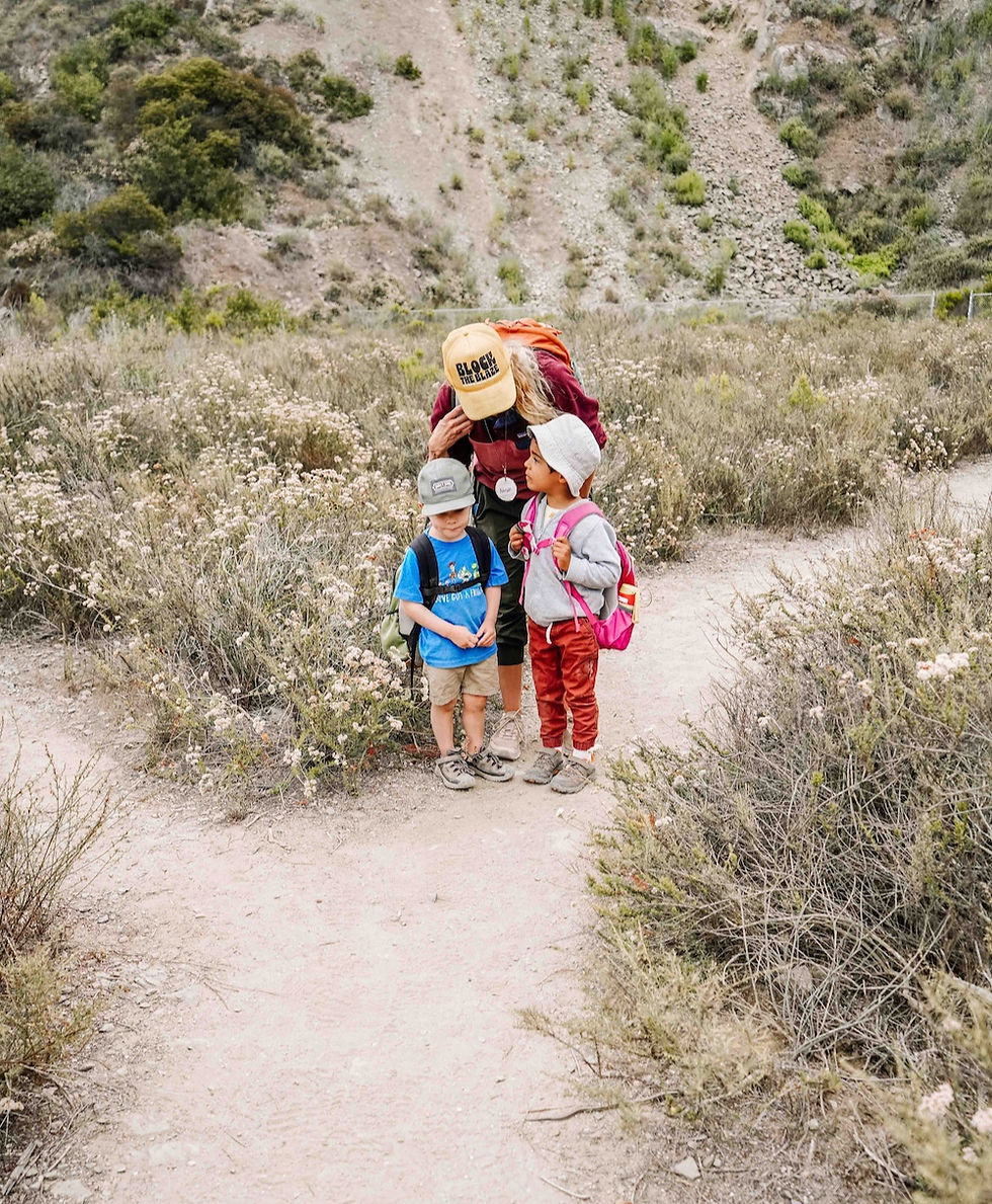 Children with their teacher observing a snake safely in the forest at San Elijo Lagoon in Cardiff, connecting literacy sounds to real nature experiences.