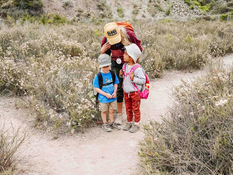 Children with their teacher observing a snake safely in the forest at San Elijo Lagoon in Cardiff, connecting literacy sounds to real nature experiences.